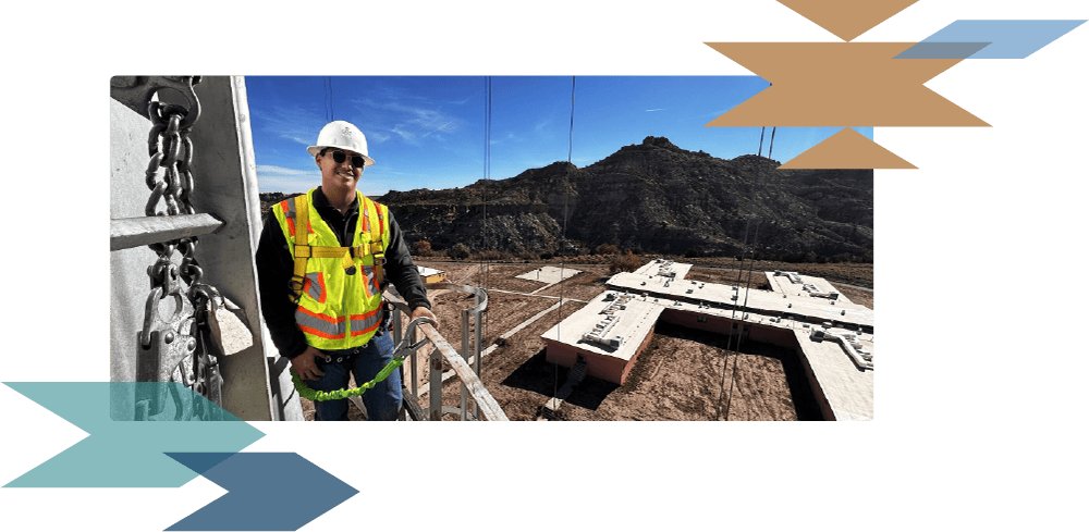 Tepa intern in safety vest posing for photo on jobsite on elevated platform
