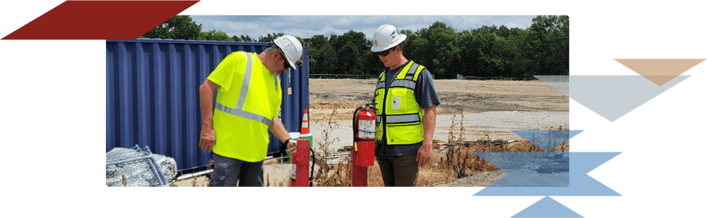 Two Tepa workers looking at fire extinguishers on a job site