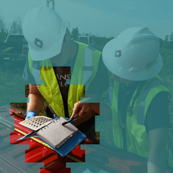 Tepa Companies workers in high-visibility safety vests and hard hats examining a chart for soil and material analysis.