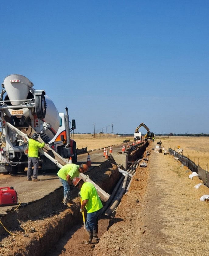 Construction crew pouring concrete for a new curb or median at the Doolittle Substation.